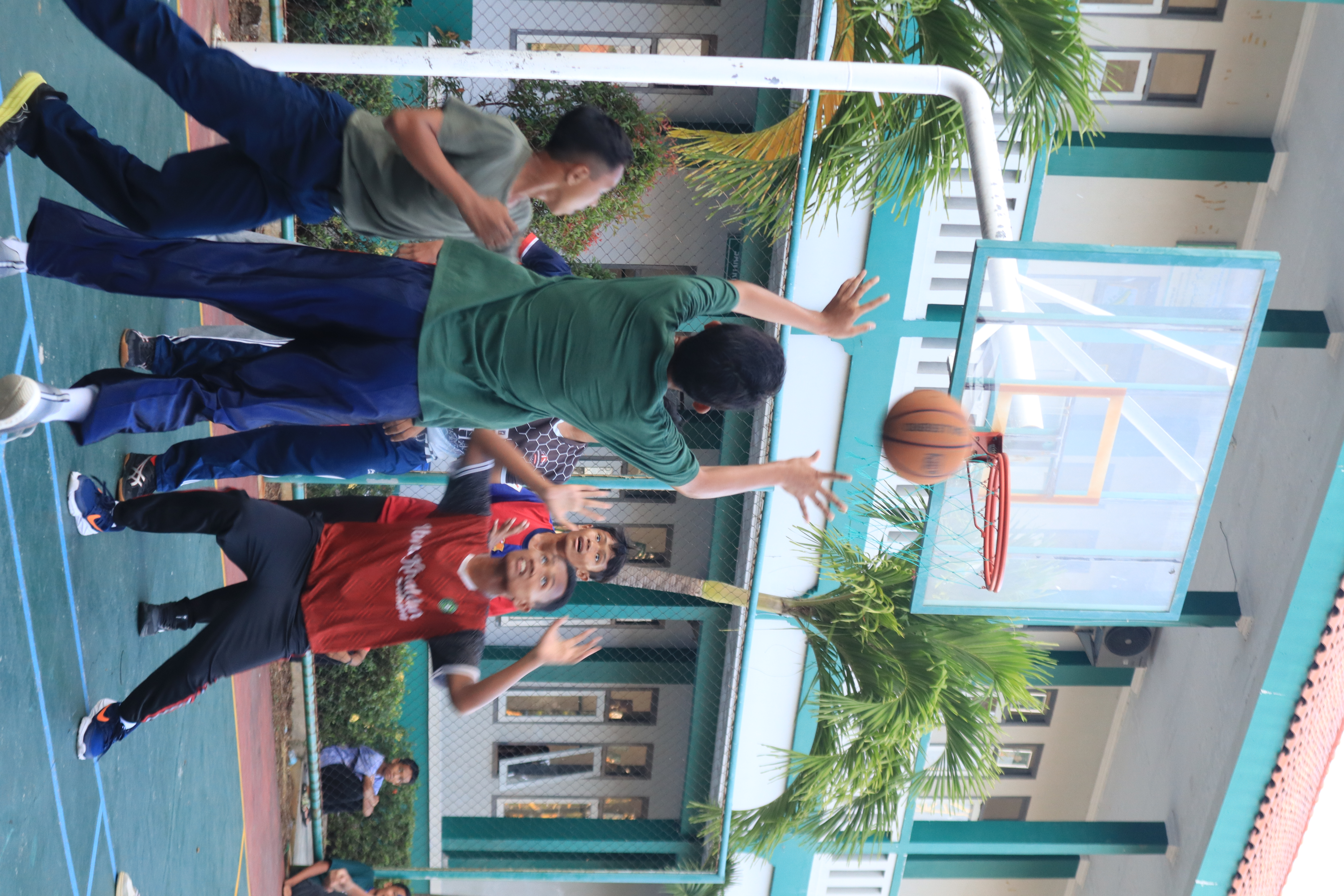 Santri bermain basket di lapangan indoor